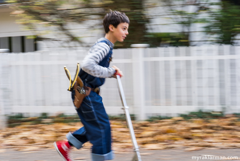 Halloween 2012 | Dennis scootering off to take care of pressing business. Mr. Wilson’s white picket fence is ablur.