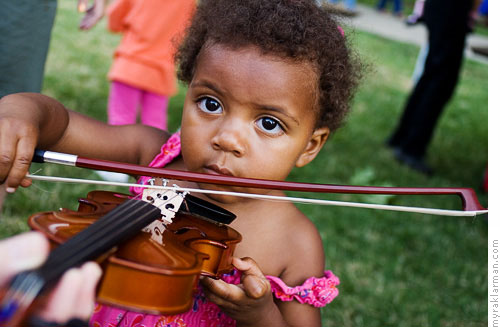 Ann Arbor Summer Festival 2007 | Playing with a miniature violin at the instrument petting zoo.