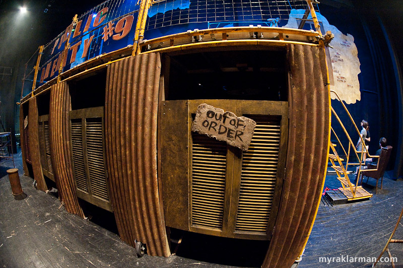 Pioneer Theatre Guild: Urinetown | Before the dress rehearsal: Public Amenity #9 (à-la-fisheye). Could this have been painted any more beautifully — “beautifully” in the sense of dilapidated, grungy, unhygienic, public-toilet-from-hell? 