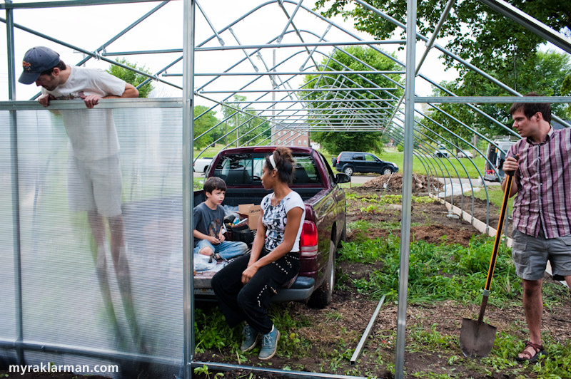 Hoop House Dreams | Shannon Brines (an extremely long-legged, Dexter-based hoop house farmer) admires one of the newly installed hard-plastic end walls.