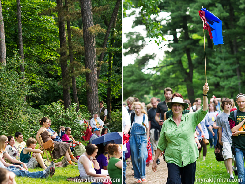 Shakespeare in the Arb: A Midsummer Night’s Dream | The audience, seated on chairs and blankets, watches the action. During the performance I attended, umbrellas provided protection from both the sun and rain. | UM lecturer Kate Mendeloff not only has directed every Shakespeare in the Arb production, but with flag in hand, she also leads the audience to the various locations within the Arb where the action is staged. 