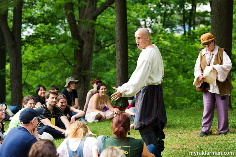 Shakespeare in the Arb: A Midsummer Night’s Dream | In some scenes there is hardly a barrier between the actors and the audience. The story features a play within a play — here, the character Bottom (Sam Dodge) constantly interrupts director Peter Quince (Jane Glass) as he attempts to cast the play.