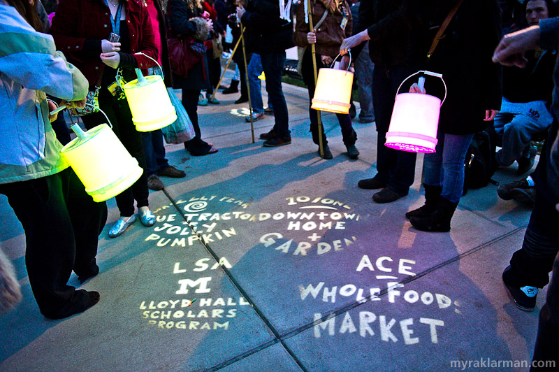 FoolMoon 2011 | Sponsors were acknowledged in the most extraordinary way: buckets were outfitted with flashlights and covered with gobos (or stencils) allowing the sponsors’ names to be projected onto nearby surfaces, persons, buildings, etc. I love that FestiFools came up with such an imaginative, appropriately Foolish, and frankly beautiful way to thank its sponsors (talk about glowing praise).